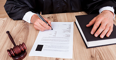 Man filling out a form; laptop in background