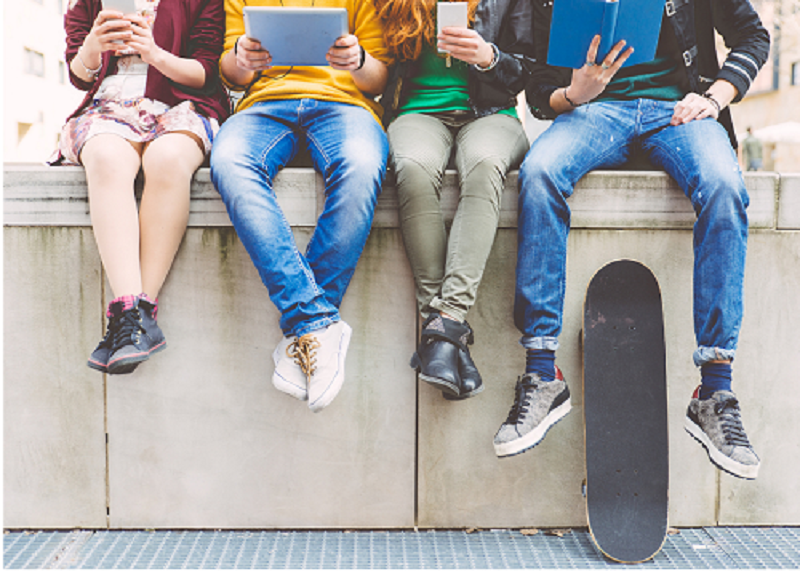 teens sitting on a ledge reading